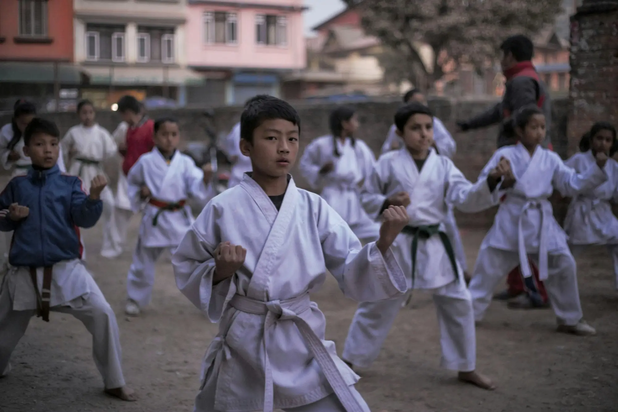 Groep kinderen in vechtsportpak tijdens een training